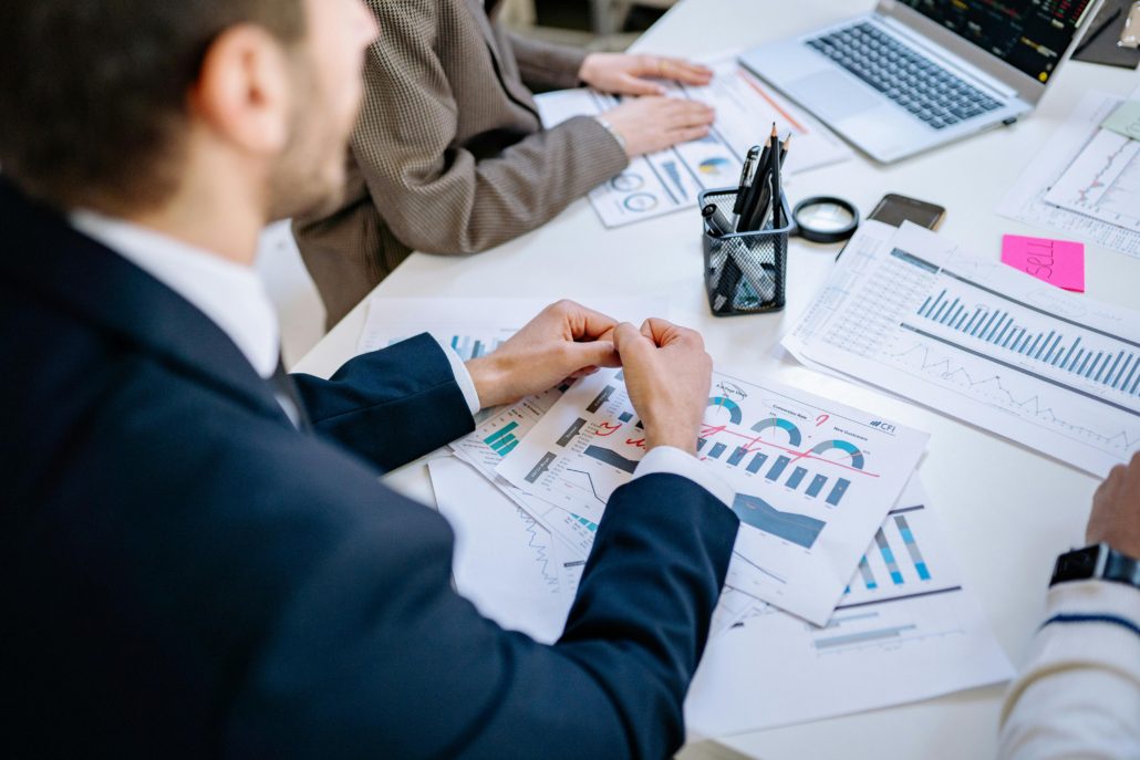 Business team analyzing financial graphs at a meeting table, fostering collaboration in an office environment.